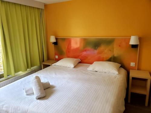 1 dormitorio con 1 cama blanca y 2 almohadas en Cottage 6p-les hauts de bruyères-765, en Chaumont-sur-Tharonne