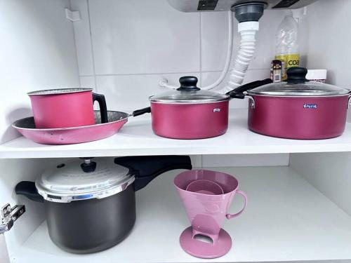 three pots and pans on a shelf in a kitchen at Apartamento vista mar in Praia Grande