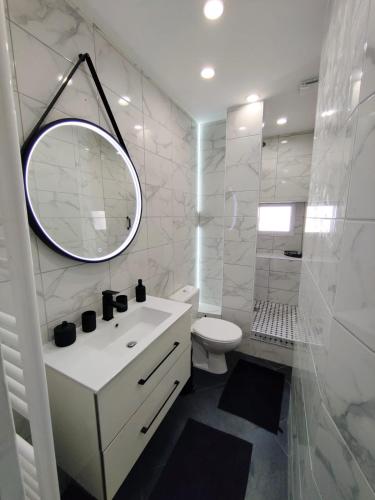 une salle de bain blanche avec un lavabo et un miroir dans l'établissement Le Coeur de Cahor! 2 bedroom luxury rental 85m2., à Cahors