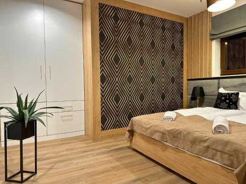 1 dormitorio con 1 cama y una maceta en Apartamenty Satoła Ciągłówka en Zakopane