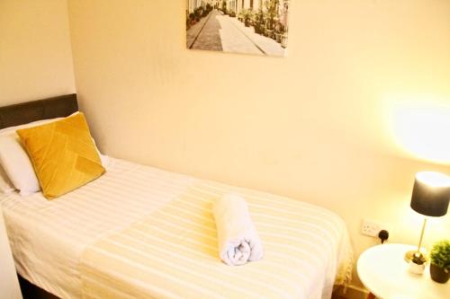 une chambre d'hôtel avec un lit et une serviette. dans l'établissement EasyRest House Peterborough - 6 Beds & Private Parking - Easy Location - Access to A1, City Centre & Shops, à Peterborough