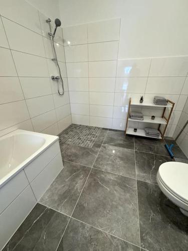 uma casa de banho com um chuveiro, um WC e uma banheira em Meine gemütliche Auszeit em Wolfsburg