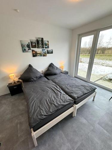 uma cama grande num quarto com uma janela grande em Meine gemütliche Auszeit em Wolfsburg