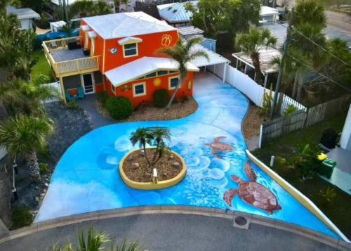een huis met een schilderij aan de zijkant van een zwembad bij Summer Rayne in Cocoa Beach