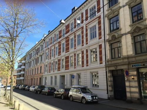 a large building with cars parked on the side of a street at Keybutler Royal Park Studios in Oslo