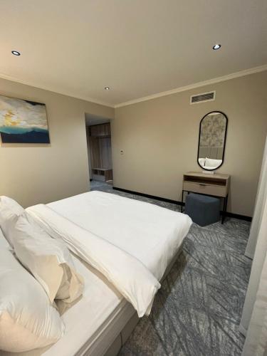 a bedroom with a white bed and a mirror at Villa Park in Al Khobar