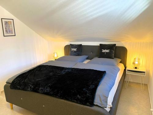 una camera da letto con un grande letto con cuscini bianchi e neri di Zentrale Ferienwohnung am Buhlschen Park in Deidesheim a Deidesheim