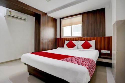 ein Schlafzimmer mit einem großen Bett mit roten Kissen in der Unterkunft Super OYO Flagship Hotel Everest Lodging Vashi in Mumbai