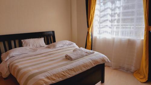 a bed with towels on it in a room with a window at MaGiK Furnished All Ensuite 2 bedroom Apartment in Nyeri