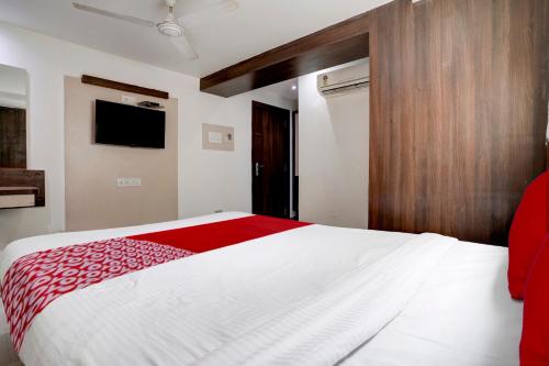 ein Schlafzimmer mit einem großen weißen Bett mit einer roten Decke in der Unterkunft Super OYO Flagship Hotel Everest Lodging Vashi in Mumbai