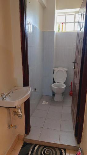 ein Bad mit einem WC und einem Waschbecken in der Unterkunft MaGiK Furnished All Ensuite 2 bedroom Apartment in Nyeri