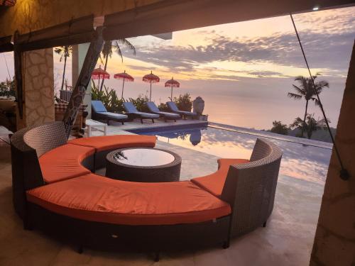 a pool with chairs and a table next to a pool at Villa Umbrella Lombok in Senggigi 