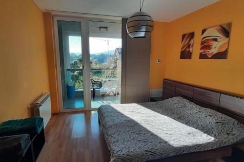 een slaapkamer met een bed en een groot raam bij Quiet Mountain Home, Free Parking & View in Sofia