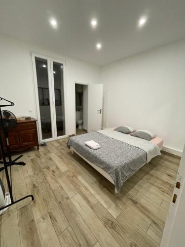 une chambre avec un lit et un parquet dans l'établissement Chez Sophie, à Toulon