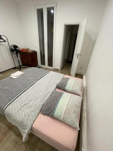 une chambre avec un lit et un miroir dans l'établissement Chez Sophie, à Toulon