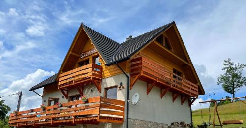 dom z drewnianymi balkonami po jego stronie w obiekcie Gazdówka na Mosornym Groniu w Zawoi
