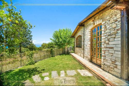a brick house with a yard next to a fence at B&B La Torretta in Maratea