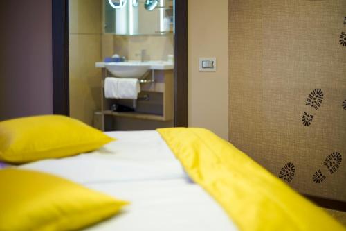 a bedroom with a bed with yellow pillows and a sink at Aktivhotel Santalucia in Nago-Torbole