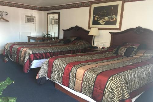 a hotel room with three beds in a room at Colonial Inn Extended Stay by OYO New Ulm in New Ulm