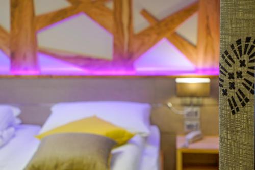 a bedroom with a bed with purple lights on it at Aktivhotel Santalucia in Nago-Torbole