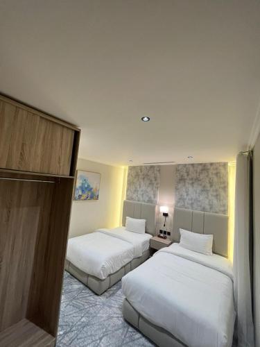 two beds in a hotel room with white sheets at Villa Park in Al Khobar