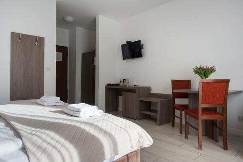 a bedroom with a bed and a desk and a chair at MariSol in Świnoujście