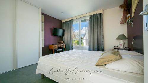 EVASION MARINE appartement VUE MER 2-4 personnes في كونكارنو: غرفة نوم بسرير كبير ونافذة