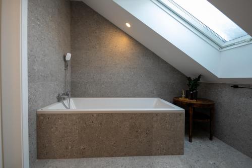 a bath tub in a bathroom with a skylight at Hiša Zima in Gozd Martuljek