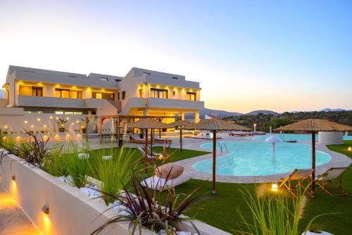 a villa with a swimming pool at dusk at KALOS LUXURY HOMES, BEACHSIDE EXPERIENCE VOULISMA in Istron