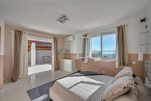 ein Schlafzimmer mit einem Bett und einem großen Fenster in der Unterkunft Barbouillet - Maison avec piscines partagées in Joyeuse