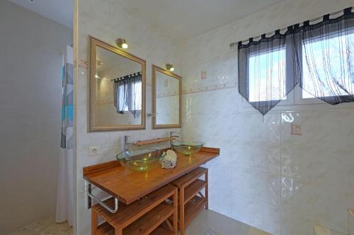 ein Badezimmer mit zwei Glasschalen auf einer Holztheke in der Unterkunft Barbouillet - Maison avec piscines partagées in Joyeuse