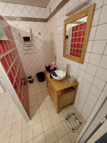 une salle de bain avec un lavabo et un miroir dans l'établissement Apt Nuits au pied du Phare, à Calais