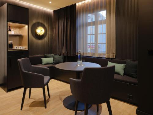 a dining room with a table and chairs and a couch at Hotel am Sophienpark in Baden-Baden