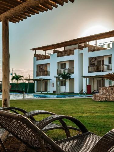 a view of a building with chairs in a yard at Quality - Boas Vistas in Canoa Quebrada