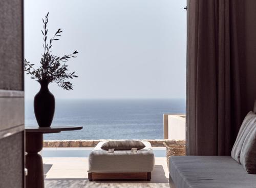 a living room with a view of the ocean at The Royal Senses Resort & Spa Crete, Curio Collection by Hilton in Panormos Rethymno