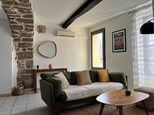 a living room with a green couch and a table at Le cocon in Notre-Dame-de-la-Rouvière
