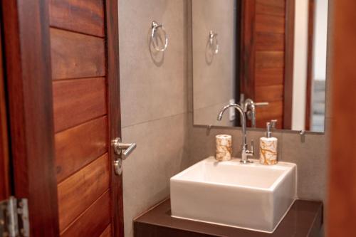 a bathroom with a white sink and a mirror at Quality - Boas Vistas in Canoa Quebrada