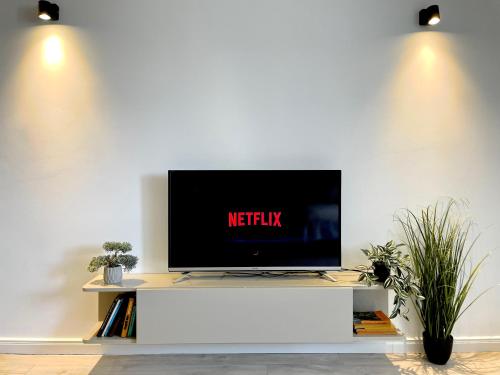 a flat screen tv on a white wall at Ultracentral modern city view apartment in Târgu-Mureş