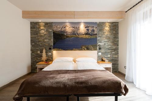 - une chambre avec un grand lit orné d'une peinture murale dans l'établissement Hotel Gruppo Brenta, à Andalo