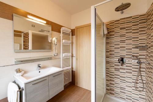 La salle de bains est pourvue d'un lavabo et d'une douche. dans l'établissement Hotel Gruppo Brenta, à Andalo