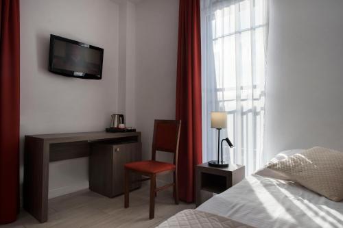 a bedroom with a bed and a desk and a television at MariSol in Świnoujście
