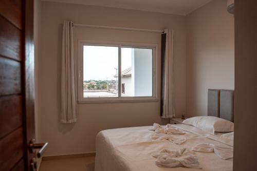 a bedroom with a bed with two towels on it at Quality - Boas Vistas in Canoa Quebrada