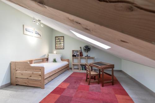 - une chambre mansardée avec un lit et une table dans l'établissement Chalet ZigueZague - Calme - Proche Thermes, à Saint-Gervais-les-Bains