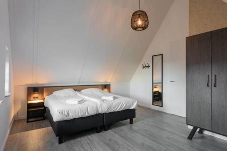 een slaapkamer met een bed en een dressoir bij Hello Zeeland - Vakantiewoning Knuitershoek 88 