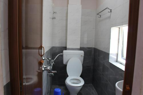 a bathroom with a toilet and a sink and a window at CHENNAI PALACE in Chennai