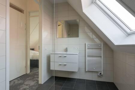a bathroom with a sink and a mirror at Hello Zeeland - Vakantiewoning Knuitershoek 64 