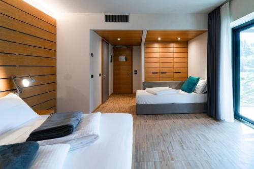 a bedroom with two beds and a window at Lake Front Hotel Mirage in Riva del Garda