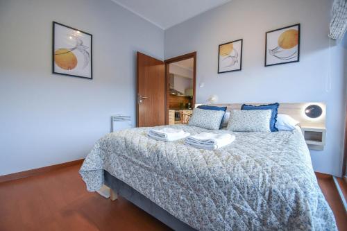a bedroom with a bed with two towels on it at Apartamenty Na Wyspie - Baltic Park - Apartamenty z sypialnią i parkingiem - ul Uzdrowiskowa 24-34 in Świnoujście