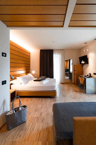 a hotel room with a bed and a desk at Lake Front Hotel Mirage in Riva del Garda