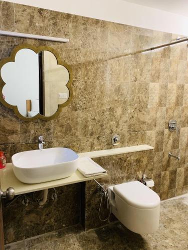 a bathroom with a sink and a toilet at WOODS - Mangalyam Meadows in Valsad